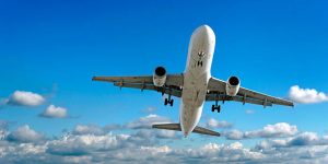 jet airplane landing in bright cloudy sky, panoramic frame