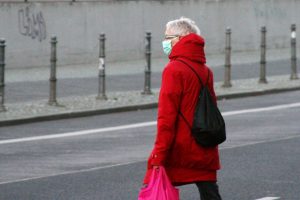 Seniorin mit Mundschutz und Einkaufstüte