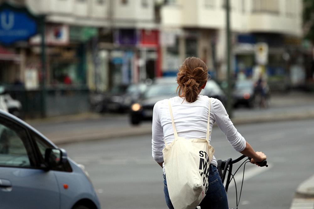 Junge Frau auf Fahrrad im Straßenverkehr