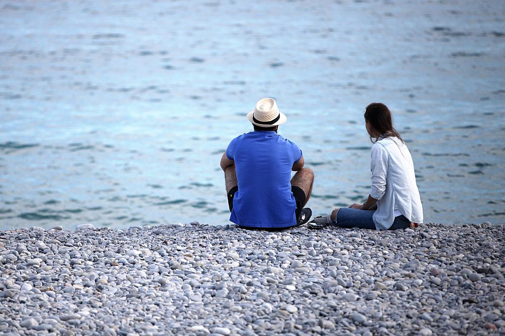Mann und Frau sitzen am Strand