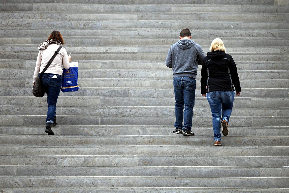 Drei Personen gehen eine Treppe hinauf (Archiv)