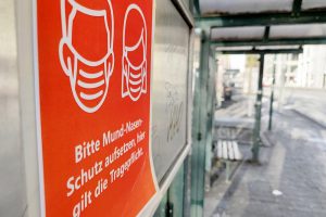 Hinweis auf Mund-Nasen-Schutz an einer Straßenbahnhaltestelle