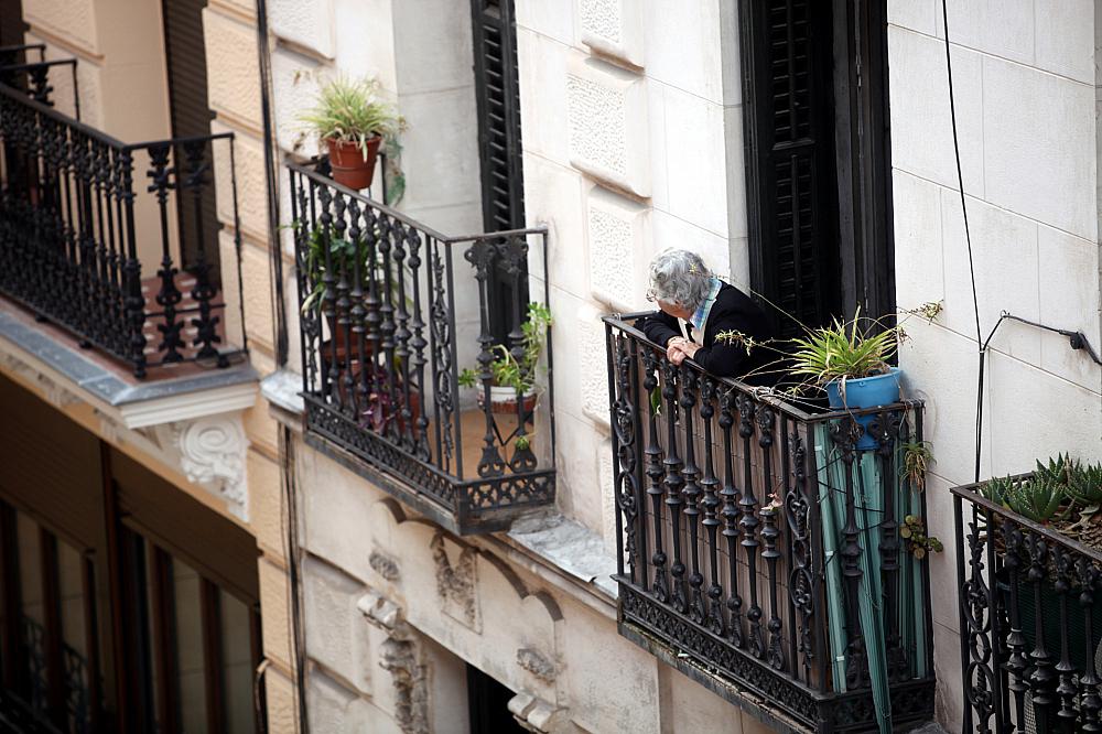 Seniorin schaut von einem Balkon (Archiv)