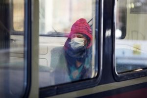 Frau mit Schutzmaske in einer S-Bahn