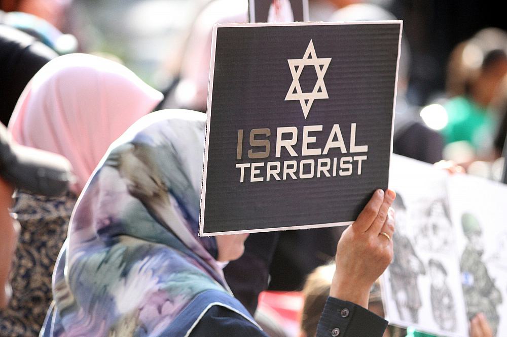 Demonstrantin mit "Isreal Terrorist"-Plakat