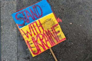 Schild "Stand with Ukraine" liegt auf dem Boden (Archiv)