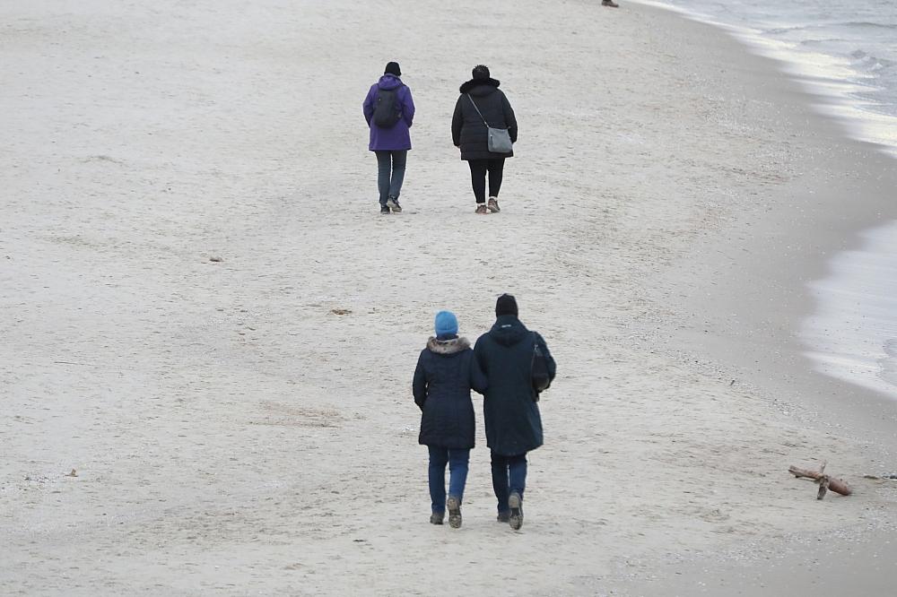 Paare gehen am Strand spazieren